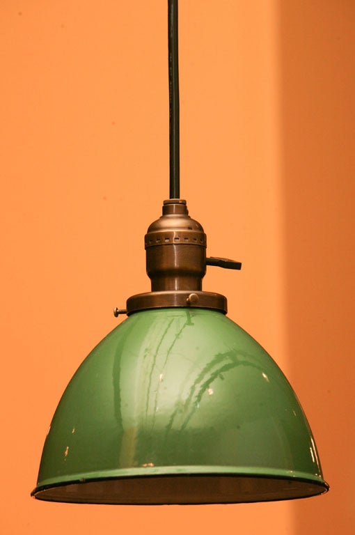 A group of hanging pendant fixtures, with hunter green exterior surface and frost white interior enameling, and thin black enamel edging, at bottom.  Includes solid brass hardware and matching ceiling canopy.  Electrical Parts and black rubber
