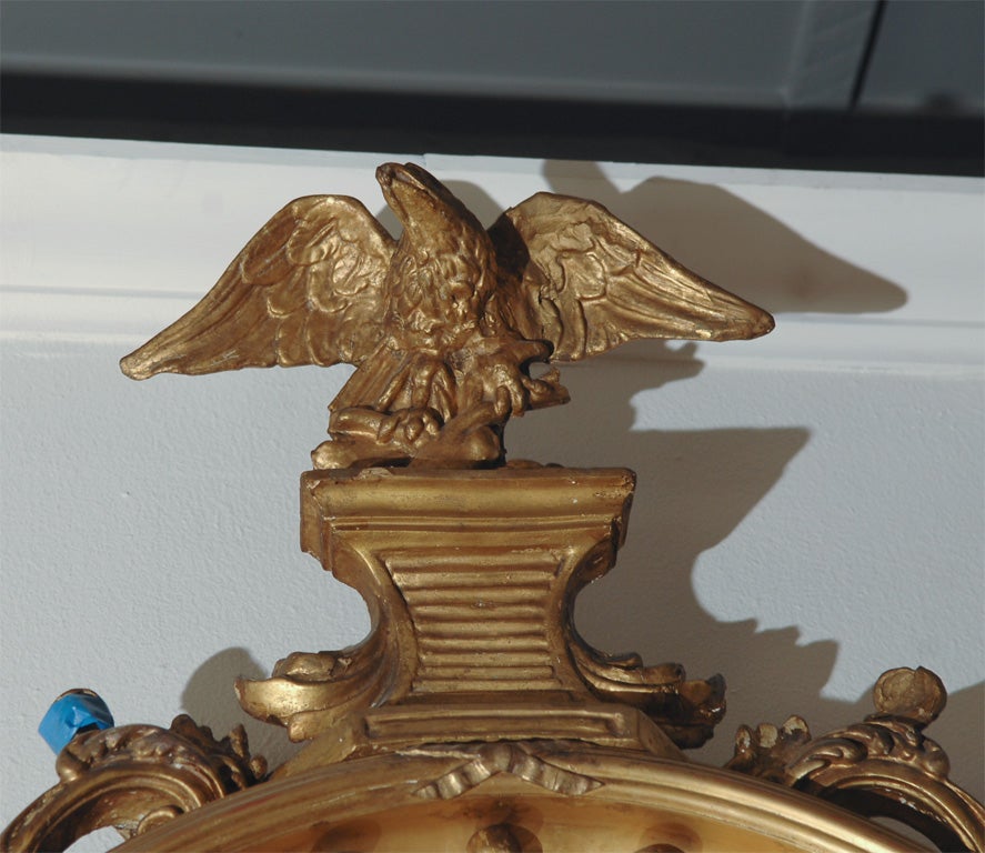 a George III carved giltwood bull's-eye/convex mirror, frame surmounted by an eagle