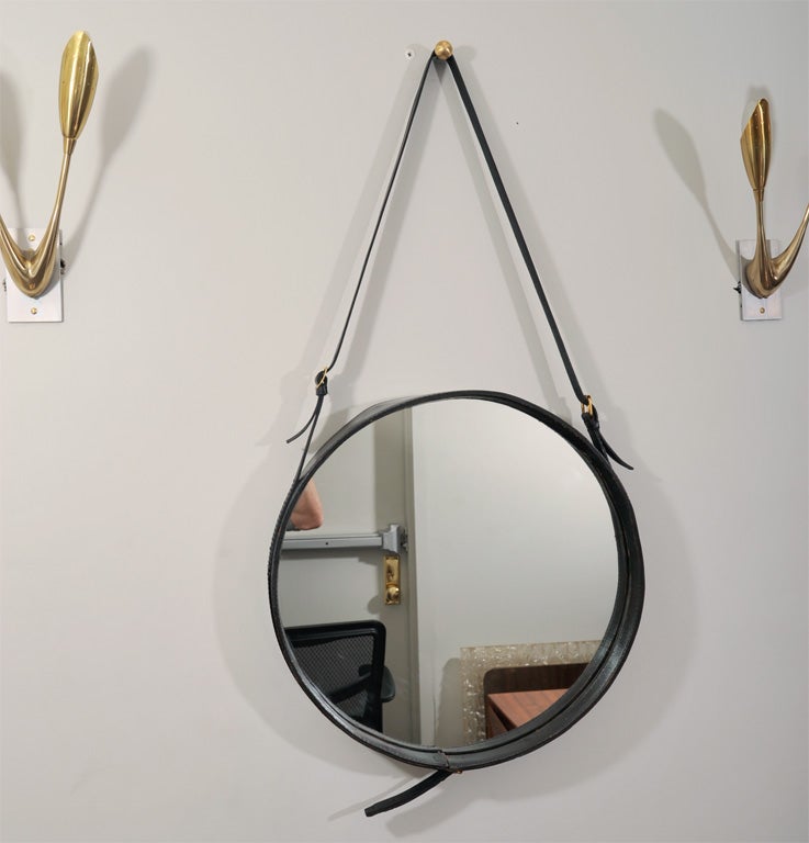 Elegant pair of Jacques Adnet mirrors with a belt. In the rare 18