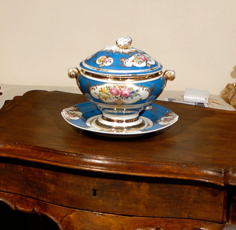 A French blue soup tureen with its platter from the late 19th century. This French lidded soup tureen features an exquisite deep blue color, accented by a delicate floral décor made of pink, yellow, purple and blue flowers among others. The lid is
