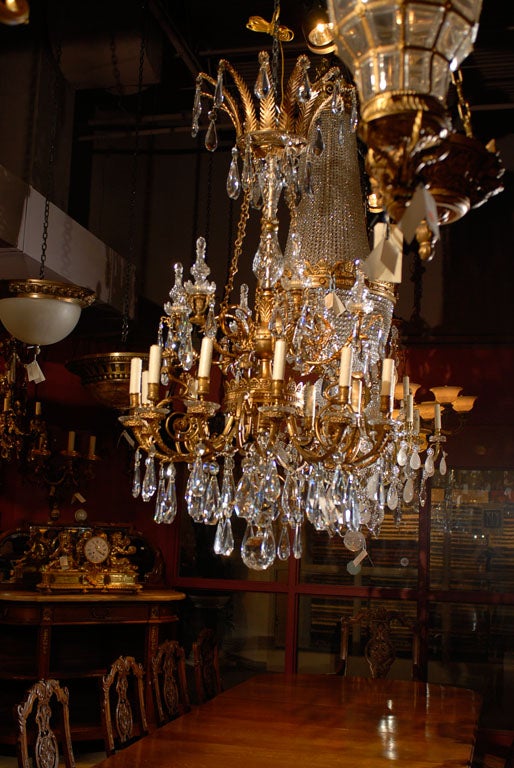 Exquisite and rare Empire style chandelier with elaborate gilt bronze frame and crystal pyramids and pendalogues. France, circa 1900. 
Dimensions: Height 58