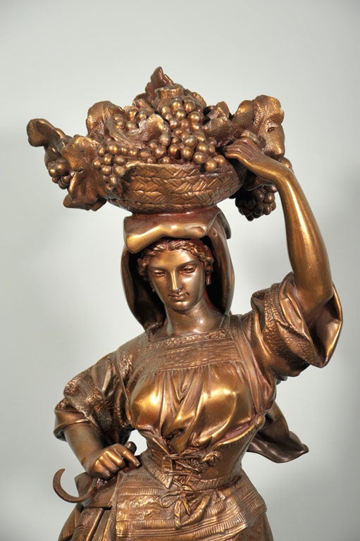 Signed bronzed statue of a girl bearing fruit basket, with sickle in other hand, this sculpture is probably of Mid-Century and magnificently executed, we provide rentals for stylists, photo shoot and props for movie sets.