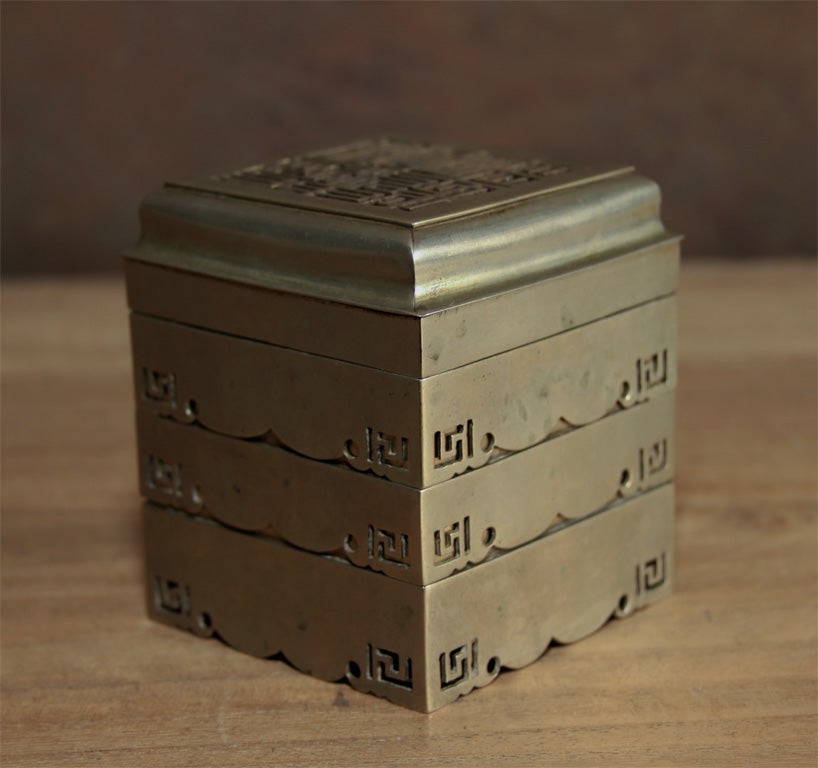 Chinese paktong incense clock. The cube-like clock with three stacked tiers and intricately pierced lid. The uppermost tier with pierced incense pattern, and tapper with handle, used to layout a path of incense, which would burn at a prescribed rate