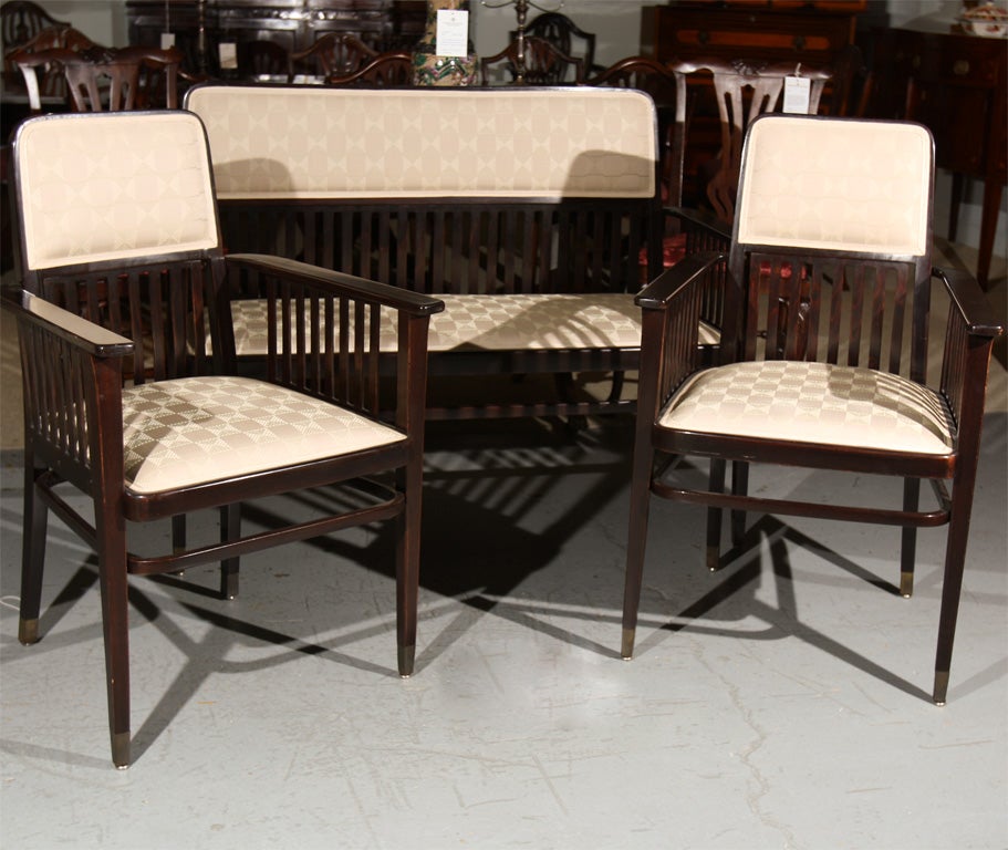 Viennese salon suite in ebonized beachwood by Marcel Kammerer upholstered period style fabric. The slat back ornamentation and capped brass feet were typical of the Vienna Secessionist movement.  Kammerer, a well known Austrian furniture designer,