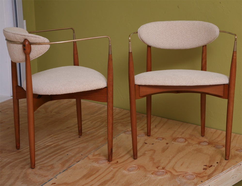 SOLD APRIL 2010 Glamorous, urbane Danish modern describes this pair of armchairs by Ib Kofod Larsen for Selig, c.1956.  At once sculptural, sensual and comfortable, these chairs are highlighted by their shaped brass arms that orbit the backs like a