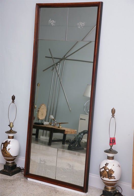 A mahogany frame surrounds the mirror which features animals representing the four seasons etched into each beveled corner.