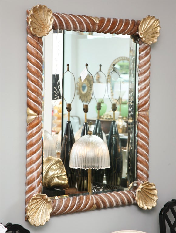 Carved and painted wood mirror with shell motif at all four corners. The shells are gilt gold in contrast to the umber tone of the carved twist pattern of the frame..