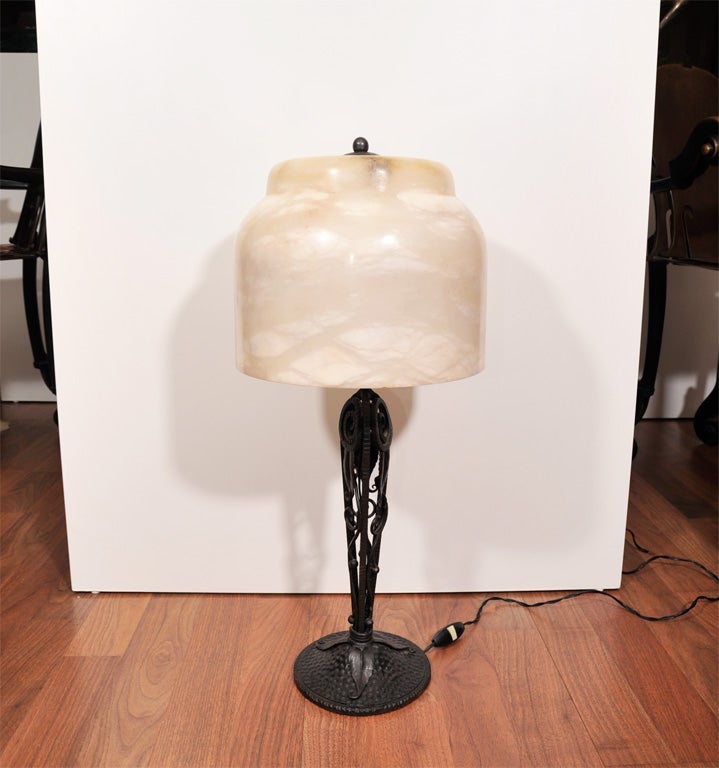 A French Art Deco wrought iron table lamp, signed

E. Brandt, from circa 1925 with an alabaster shade.
