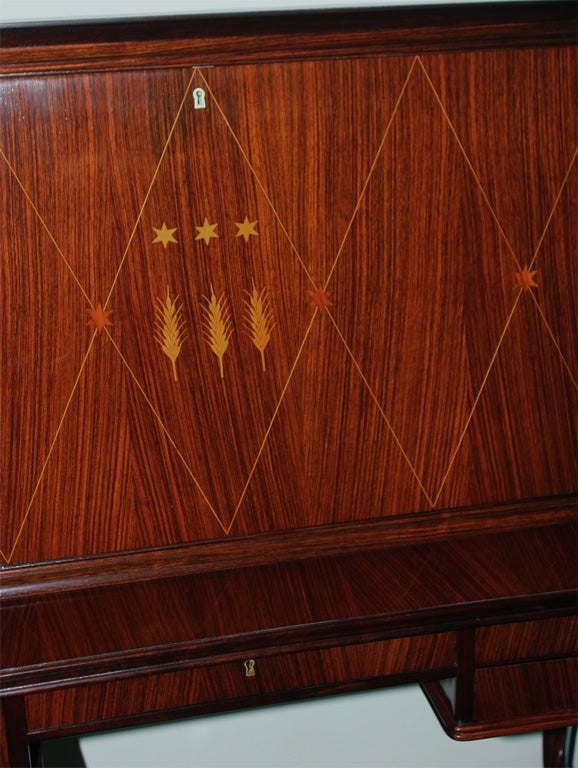 Elegant Mario Quarti art deco rosewood secretary made in 1930 in Italy. Four drawers, one of which the front drops down to hold books. Inlay drop front door reveals a beautiful mahogany interior with two drawers and five shelves.
Truly a beautiful