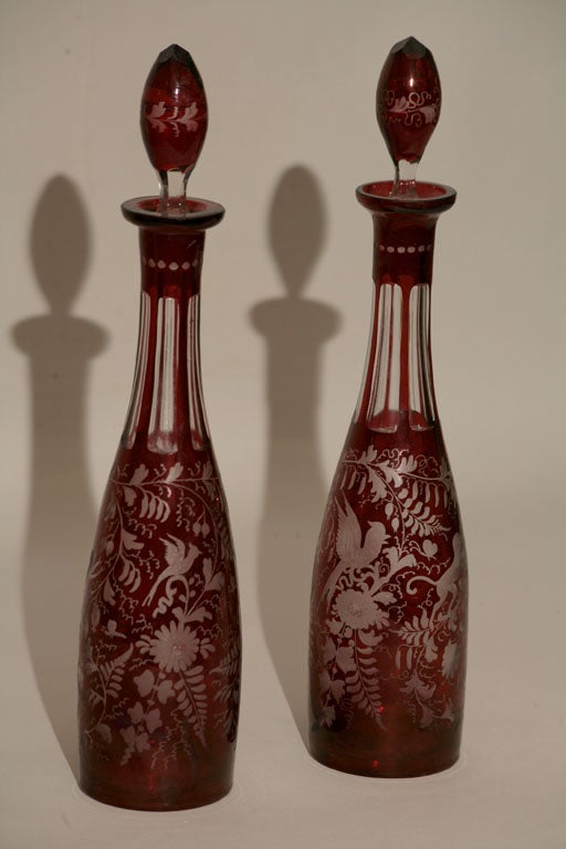 A pair of etched, flashed Ruby Glass cut to clear decorated decanters originally priced at $550.00 for the pair now reduced to: %350.00