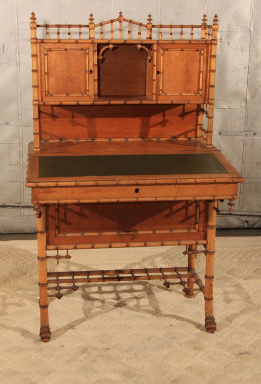 Fantastic late 19th century bird's eye maple secretary desk with faux bamboo details and lift top green leather writing surface.