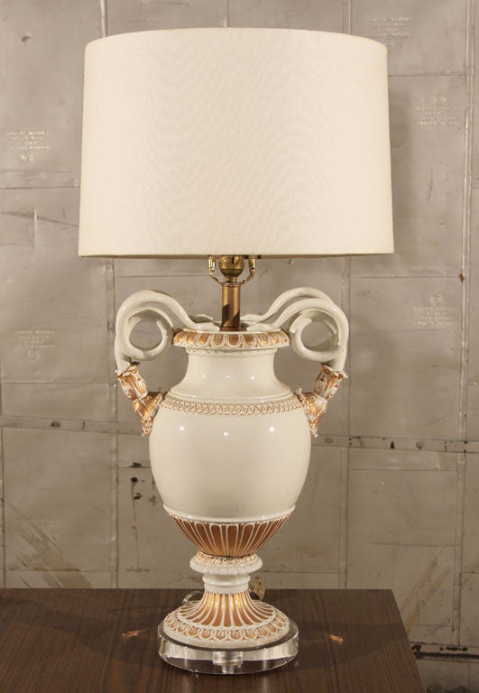 Late 19th century Meissen white porcelain urn with gilt accents and snake handles in the Louis XVI taste. Now converted into table lamp with lucite base and new wiring and fixtures.