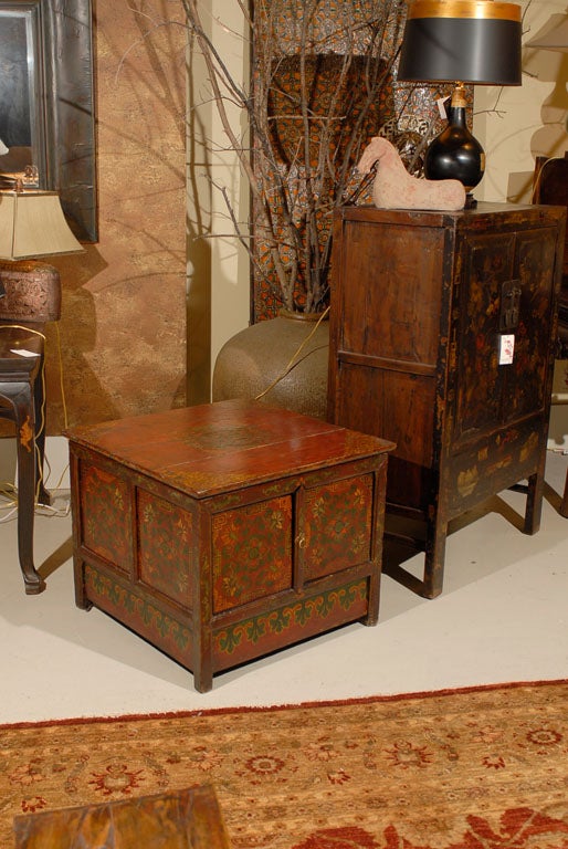 Tibetan tea/coffee table with 2 doors.  Traditional Tibetan painting on all 4 sides and top of this piece from this piece show floral motifs bordered in key fret designs.  It is rare to find a piece from this period with painting such as this on all
