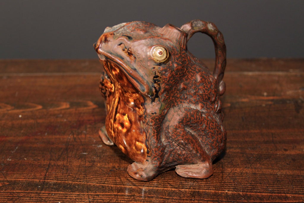 Frog Teapot<br />
<br />
A Japanese ceramic teapot in the form of a frog. The brown glazed frog sits on its haunches with a mouth that acts as a spout, small hole in his head to put in water and a simple hand pinched handle on his back.<br
