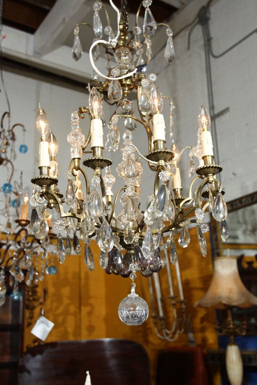 Beautiful chandelier with brass frame and candelabra arms, tiers of clear and smokey crystals.