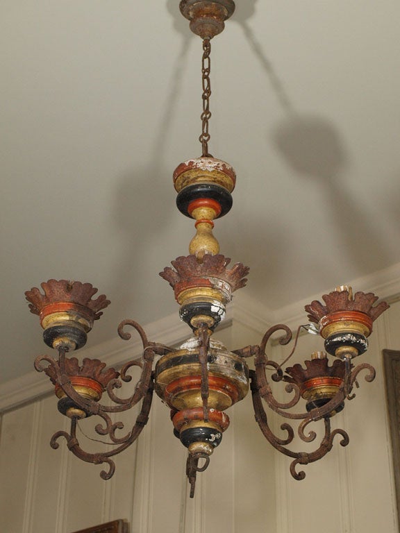 A PAIR OF 6 LIGHT, CARVED WOOD AND IRON CHANDELIERS IN THE TUSCAN STYLE.