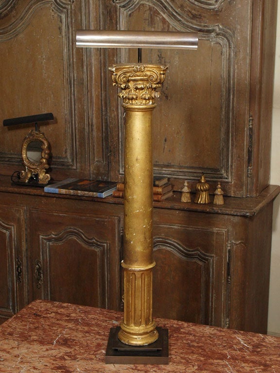 Pair of gilded wood columns (probably decorative furniture elements) made into lamps set on steel bases, illuminated with adjustable picture lights