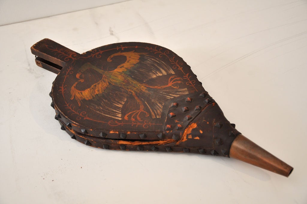 19TH C. FANTASTIC ORIGINAL PAINTED FIRESIDE BELLOWS W/ORIGINAL LEATHER AND IRON STUDS. THE FACE HAS A FOLKY PAINT DECORATED EAGLE AND DECORATED TRIM IN ALL ORIGINAL PAINT. THE COPPER BASE WHERE THE AIR COMES OUT HAS BEEN POLISHED MORE RECENTLY BUT