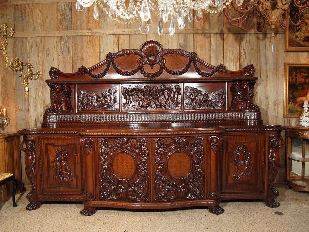 Antique carved mahogany sideboard of monumental proportions; possibly one of the finest examples of 19th century French cabinetmakers' artistry.
Exuberantly carved cupids at play in the grape vineyards, celebrating the harvest. Allegorical scenes