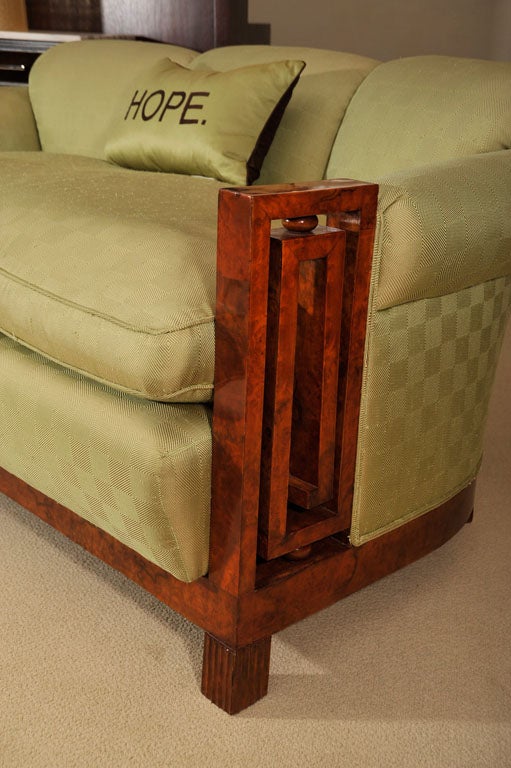 Upholstered settee with walnut burl handrests in Greek key motif.