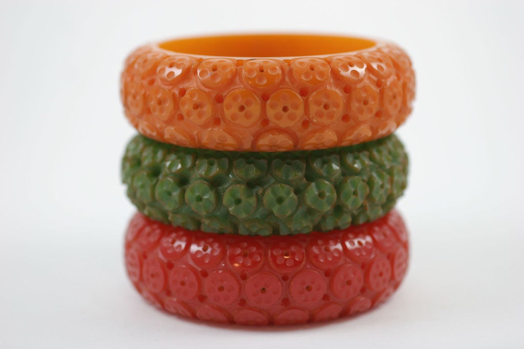 Set of three Bakelite bangle bracelets in green, red and mustard. Carved with linear lobed concentric circles.  Nicknamed 