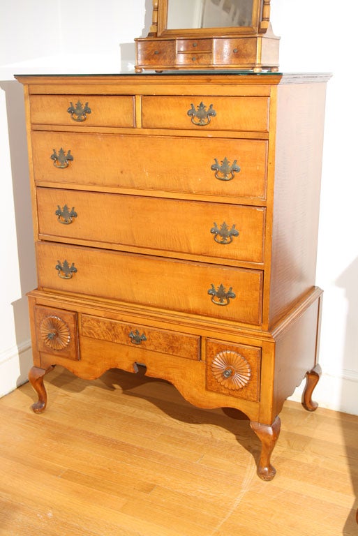 This tiger and birds eye maple dresser has eight drawers.   The two top are shallow and great for small items.  The bottom drawers are decorated with a carving and more birds eye maple wood.   The legs are turned and very pretty.   There are two