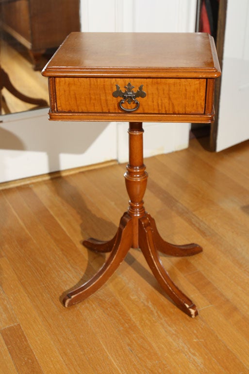 Tiger maple end table with original brass pull.  The table has a drawer and a tiger maple top.  The legs of the table could use a refinishing.   It is a sturdy table.