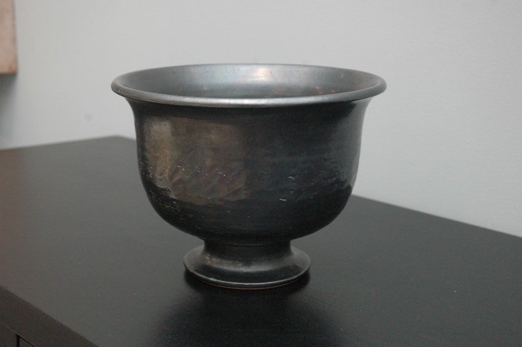 A classical form of a ceramic bowl with a gun metal glaze, signed Jean Marais