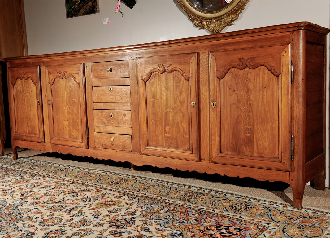 French Louis XV period cherry and mixed woods marquetry buffet-enfilade from the Picardie Region. Four doors with central bank of four drawers over scalloped skirt