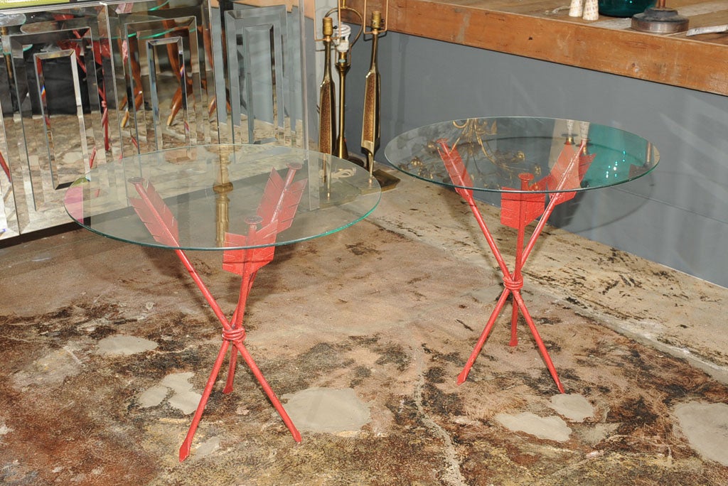 Two (2) red painted metal tables in the shape of arrows. Glass tops.