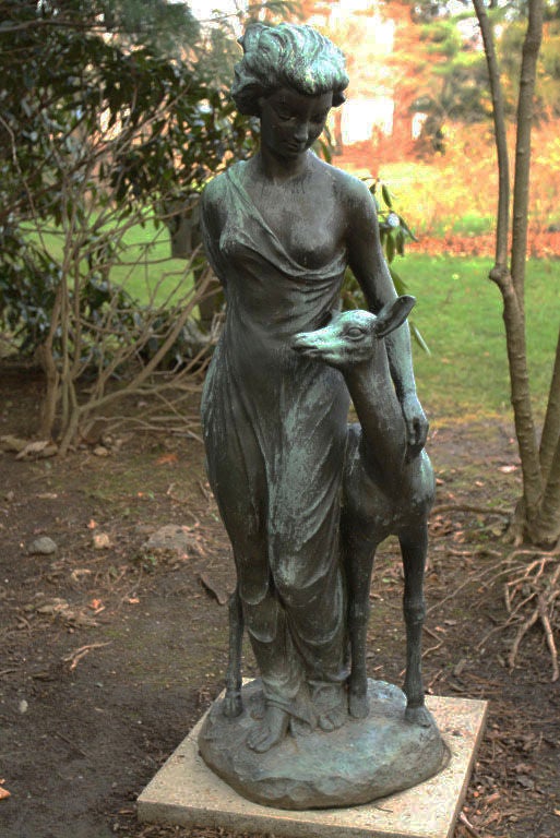A bronze maiden draped with classical robes, looking admiringly at a doe standing by her side, the maiden's proper left hand resting on the animal's neck, American, signed 