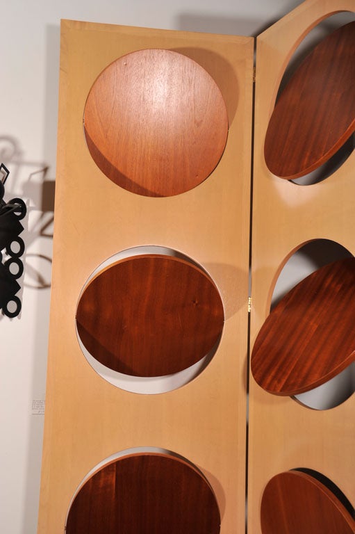 A superb custom-made, three-panel screen or room divider in pale wood with pivoting inset discs in contrasting dark wood (cherry). With a light source placed behind, you can create an interesting, adjustable glow from this unique work of art.<br
