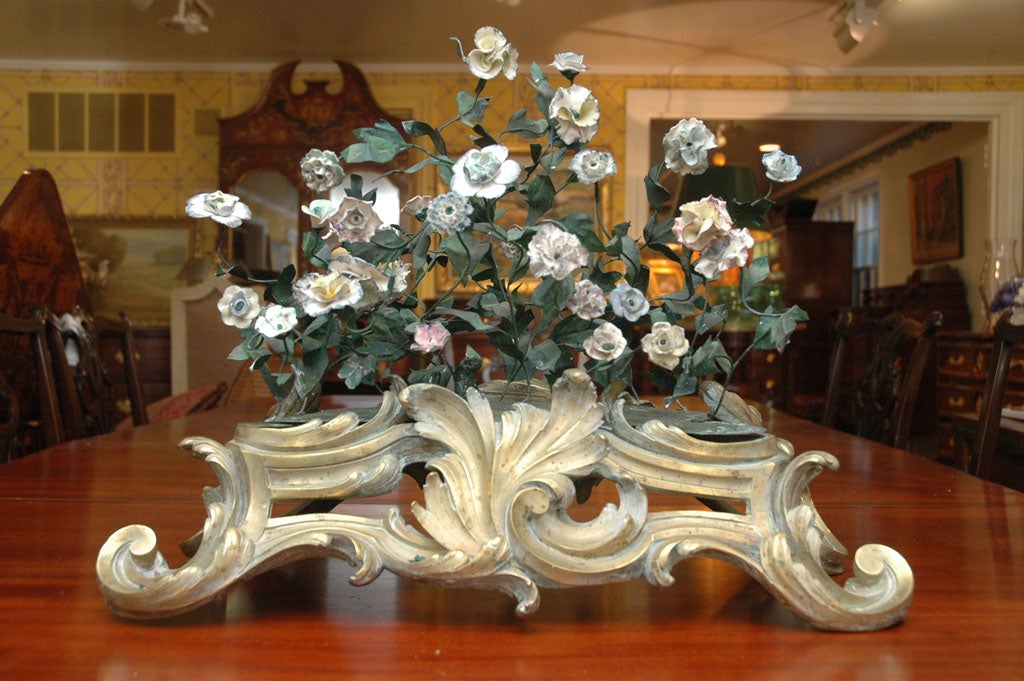 French 19th century gilt bronze base with floral arrangement of green tole leaves and

Saint-Cloud Porcelain flowers.