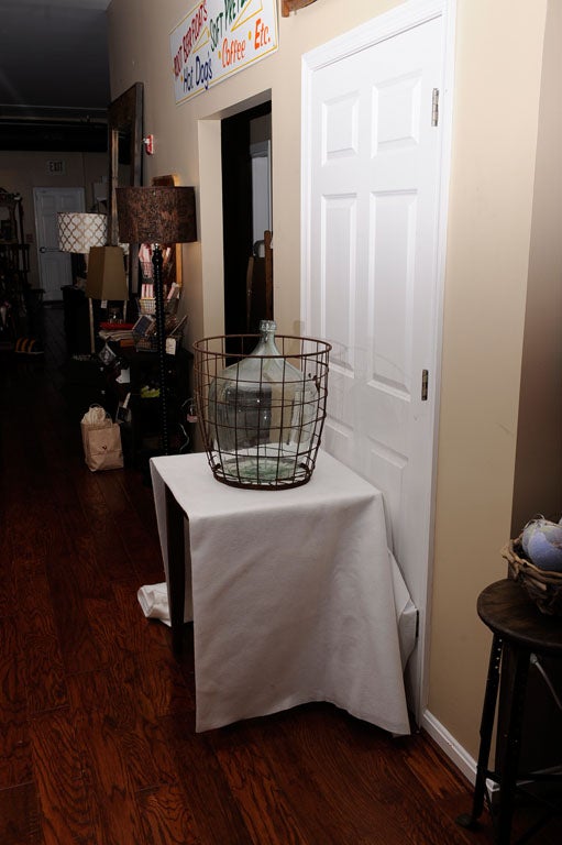 Two wonderful pieces in one!  A great French demijohn in a wonderfully rusted wire basket.