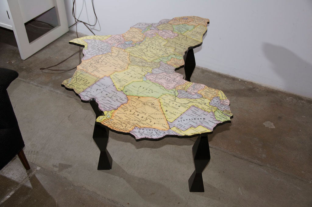 A map of Africa coffee table by Venice of California artist and furniture craftsman Doug Edge consisting of a map laminated to a birch plywood table top which is then cut to the contours of the national borders and set on wood sculpted legs.