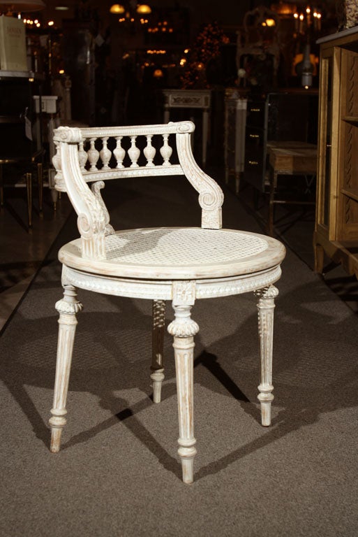 A very chic painted French vanity chair with elegantly carved details and caned seat. Stamped Jansen.