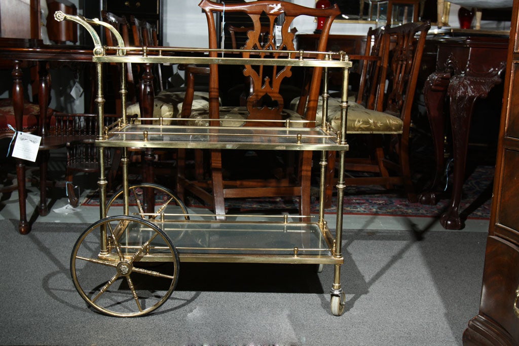 A brass with glass serving 3 tier tea cart.  The first shelf has a fantastic cut glass starburst.  Sits on 4 wheels. Attrib to Maison Jansen