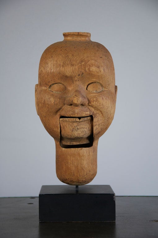 Simply carved ventriloquist's dummy head.  Very nice shape to the head and great facial features.  Really nice pattern from the tree's rings in the wood.  Presented on a custom made museum stand.