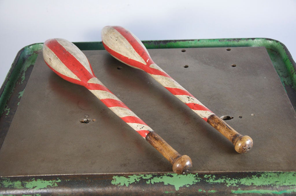 Pair of hand carved and painted juggling clubs.  Bold hand painted red stripes in very thick red paint.