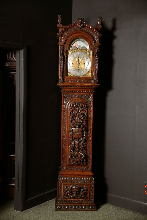 A 19th c. Carved  English Musical Longcase / Grandfather Clock.<br />
The clock is profusely carved with lions, griffins and a central coat of arms.