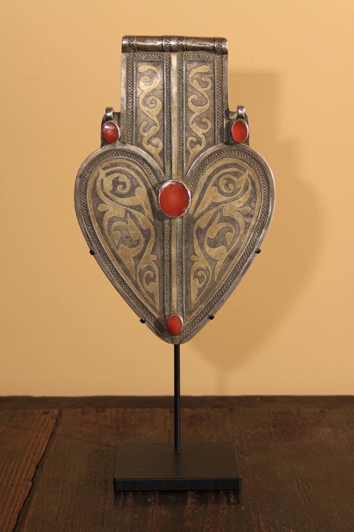 Silver asyk pendant from the Tekke tribal group of Central Asia. With bezel set cornelian gems, filigree, chase and fired-gilded surface decorations. Worn by married women in all Turkoman groups, the asyk holds plaits together on the back and acts