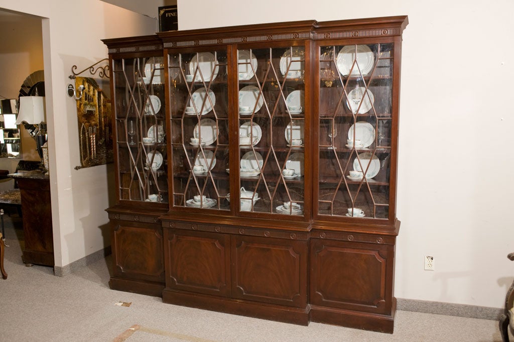 Mahogany Breakfront china cabinet by Baker, fine example of American made craftsmanship in the furniture industry. Intricate Adams style carved friezes and raised panel doors.