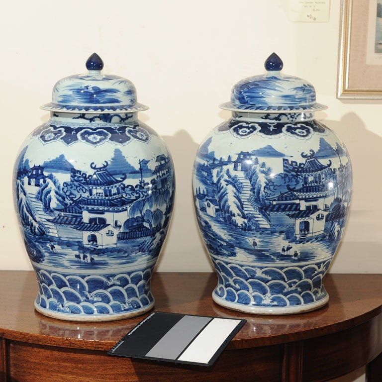Pair of blue and white Chinese covered jars in blue willow pattern.
