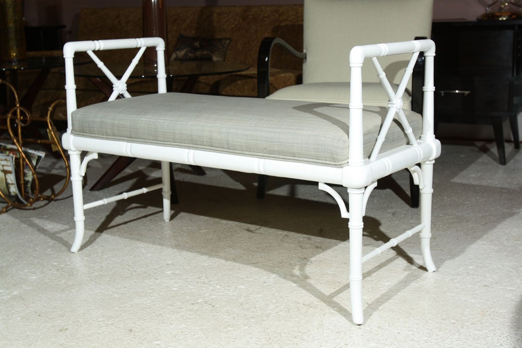 Petite white faux bamboo bench newly upholstered in a grey fabric.  The legs slightly flair out at the bottom.