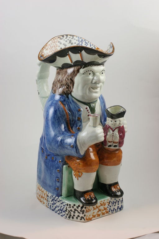 A fine English pearlware toby jug holding a small toby jug, figural handle, decorated in underglaze Pratt colors, impressed crown mark