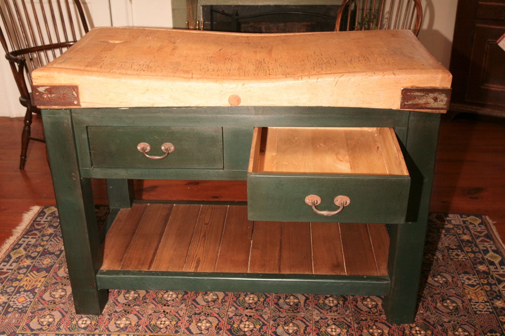 A husky old butcher block from an d English meat cutters ship has found a home a a reproduction base done in a very nice dark green paint.It has two big drawers that open from both sides and lots of storage area inside. Below that is a shelf for
