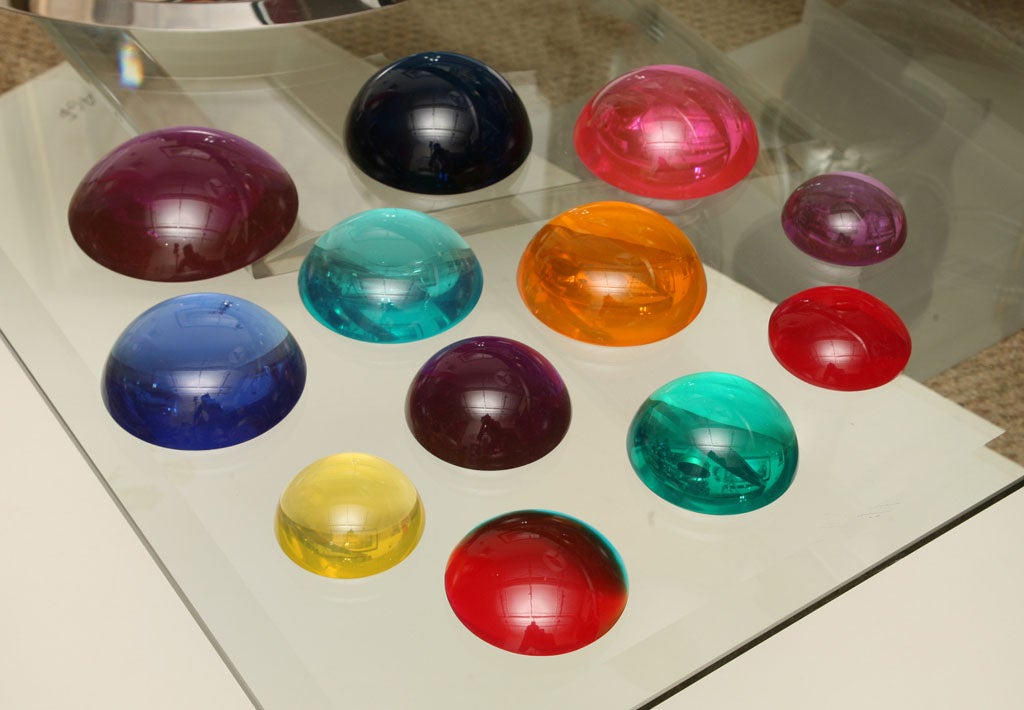 Twelve lucite sculptures or paperweights of varying sizes which add color to any desk top or as displayed art. Norman Mercer was a New York City artist who worked with lucite in many different capacities. His works reflect Pop Art as much as they do