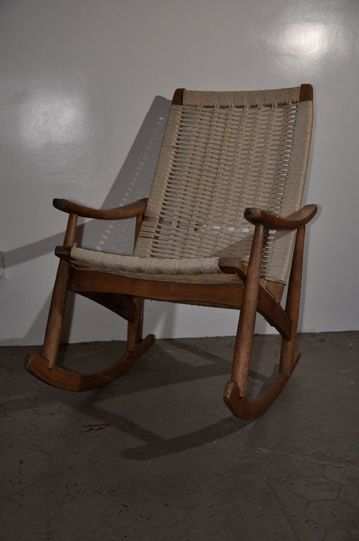 Teak wood rocker with white intertwined rope seat and back.  Expertly crafted rope seat and elegant curved lines are consistent with the rocker. The rocker is stamped on the bottom 