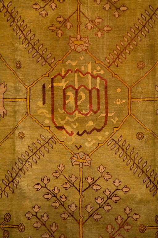 An antique Oushak is a specific style of Turkish rug, of medium to thick pile, with very subtle coloring. The weave has a coarser knot, and subsequently, a larger design print throughout the rug. Often times, Oushak rugs have a golden or faded