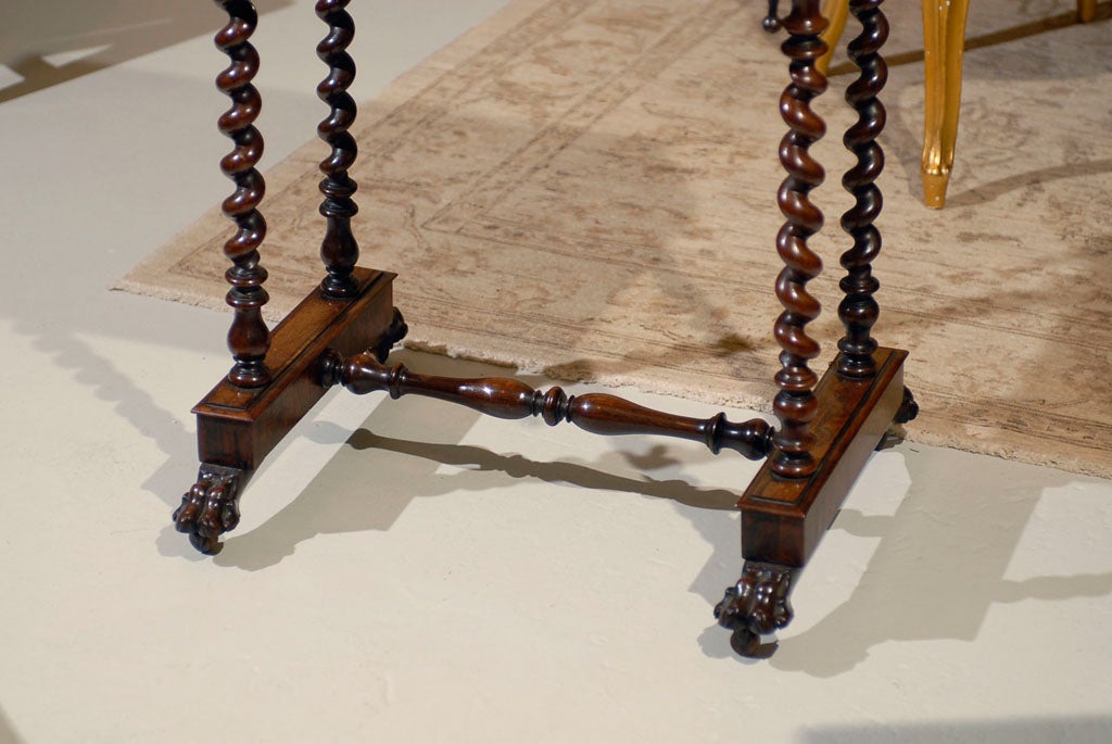 A charmning and decorative piece, the chess board top of satinwood and rosewood over a single drawer, supported on barley-twist legs united by a turned stretcher resting on carved paw feet on casters.